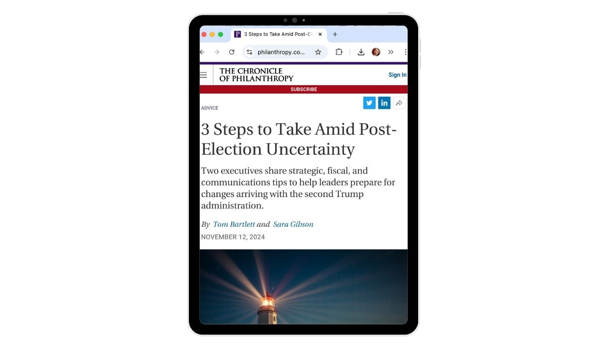 A tablet screen displays an article from The Chronicle of Philanthropy titled 
