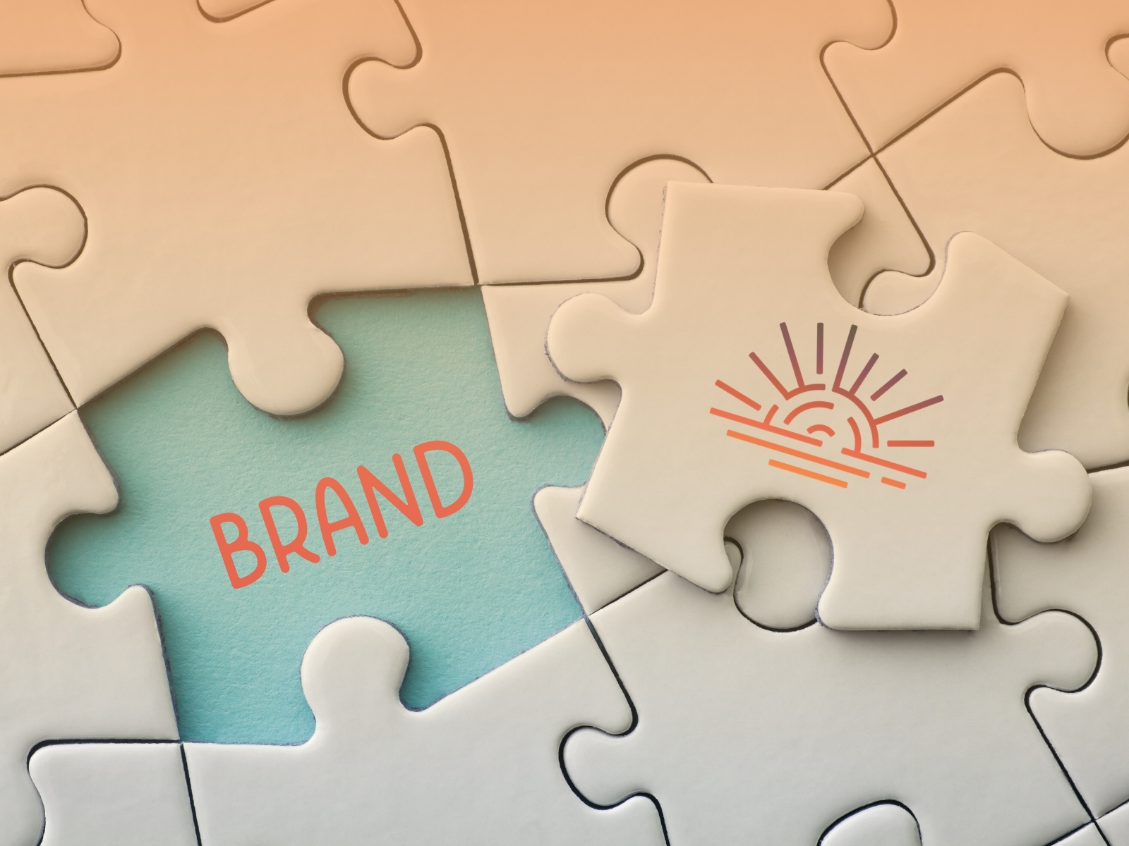 Puzzle pieces creating a complete image; one piece features a sun icon, another reveals the word "BRAND" on a blue background, symbolizing brand identity.